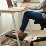 Woman using an ergonomic footrest while working at her desk.