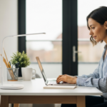 Woman working at her desk in a bright home office with supplemental lighting.